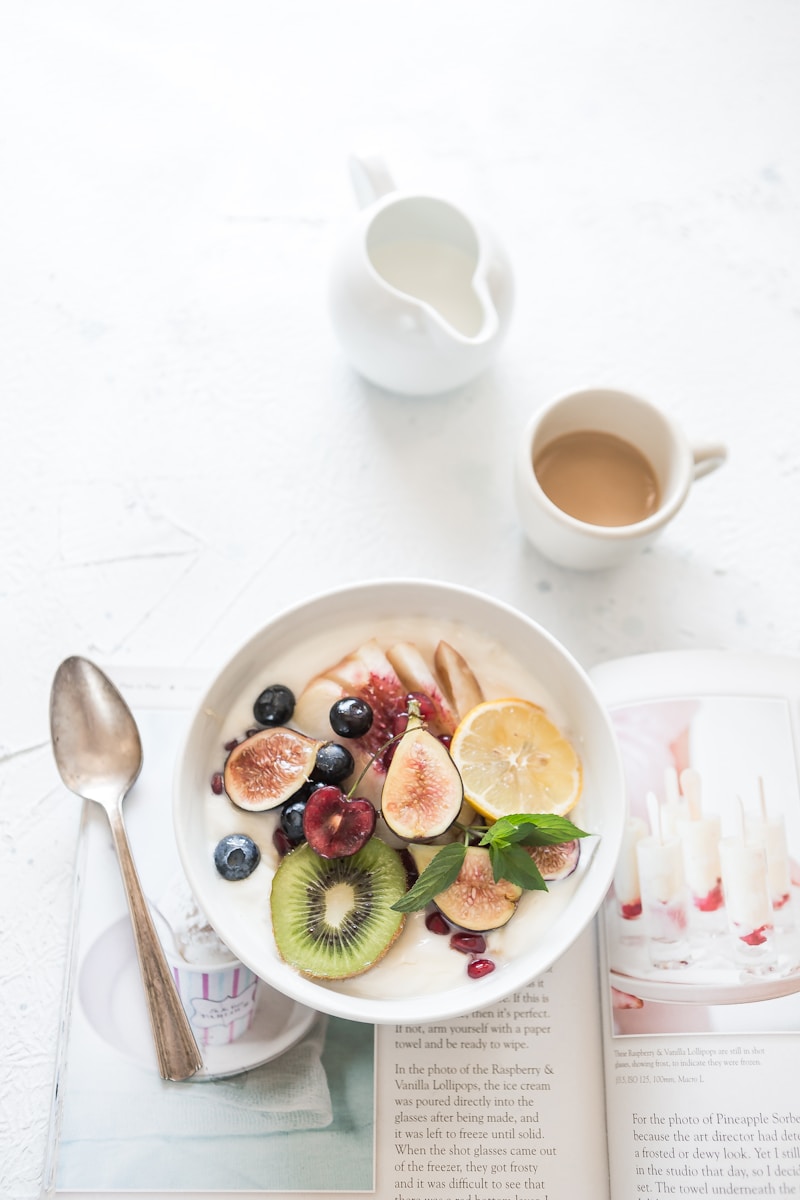 white ceramic plate beside gray steel spoon